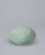 Vaisselle. A LARGE LOBED CELADON BOWL WITH INCISED PEONY