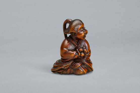 A CARVED WOOD NETSUKE OF A SEATED WOMAN HOLDING BELLS - Foto 2