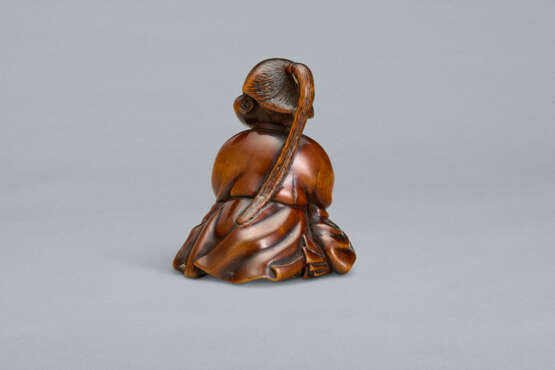 A CARVED WOOD NETSUKE OF A SEATED WOMAN HOLDING BELLS - Foto 3