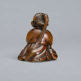 A CARVED WOOD NETSUKE OF A SEATED WOMAN HOLDING BELLS - Foto 3