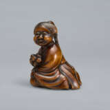 A CARVED WOOD NETSUKE OF A SEATED WOMAN HOLDING BELLS - Foto 4