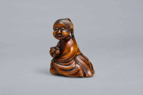 A CARVED WOOD NETSUKE OF A SEATED WOMAN HOLDING BELLS - Foto 4