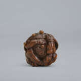 A CARVED WOOD NETSUKE OF A ONI UNDER HAT - фото 1