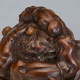 A CARVED WOOD NETSUKE OF A ONI UNDER HAT - фото 3