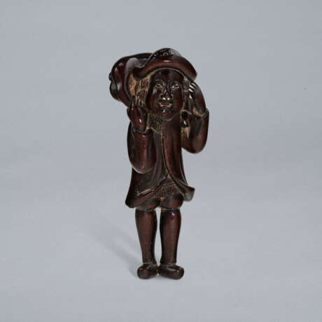 A CARVED WOOD NETSUKE OF A DUTCHMAN CARRYING A DEER - photo 1