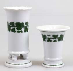 2 Meissen-Vasen, Weinlaub, dabei Kratervase, H. 9,5 cm und Vase mit 4 Füßchen auf festem Untersatz, H. 14 cm, 1. Wahl