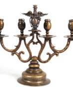 Catalogue des produits. Kerzenleuchter, Bronze, 4-flammig, glockenförmiger runder Fuß, mittig plastischer Greif (wohl ergänzt), H. 32,5 cm