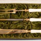 Tranchierbesteck, um 1900, 3-teilig, reich ziselierte Klingen z.T. vergoldet, Griff des Wetzstabes mit Riß, L. 28,5 cm - 24 cm, im Originaletui - фото 1