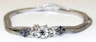 Saphir-Armband, 750er WG, 3 Stränge, mit floral gestalteter Schließe besetzt mit 7 Saphiren, Ges.-Gew. 20,7 g, L. 18,5 cm