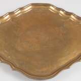 Tablett, oval geschweifter Korpus, auf 4 Tatzenfüßen, im Spiegel gravierte Darstellung eines Schäferpaares, Boden mit alter Sammleraufschrift, um ca. 1720, L. 49 cm, 41 cm - photo 1
