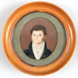 Miniatur "Porträt eines jungen Herren", 19. Jh., Öl/Platte, hinter Glas im Stoffpassepartout und rundem Holzstellrahmen, Ges.-Dm. 11,5 cm - photo 1