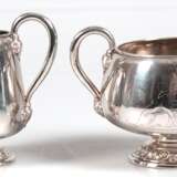 Zuckerschale und Sahnekännchen, Silber, Kopenhagen 1877, Meister Emil F. Dahl, je auf reliefiertem Rundfuß, Wandungen mit Engeldarstellungen, hochgezogene Henkel mit reliefierten Ansätzen, unterseitig monogr. und dat. 19… - photo 1