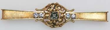 Turmalin-Brillant-Brosche, 750er GG, ausgefasst mit 1 Turmalin im Carreeschliff von ca. 0,80 ct. und 4 Brillanten von zus. ca. 0,45 ct., Si, Broschierung mit Patentsicherung, Ges.-Gew. 16,40 g, L. 8,2 cm (Wiederbeschaffu…