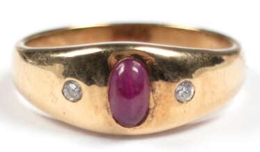 Rubin-Brillant-Ring, 585er GG, sich verbreiternde Schiene besetzt mit ovalem Rubin-Cabochon, der von 2 kleinen Brillanten flankiert wird, Ges.-Gew. 3,39 g, RG 50,5