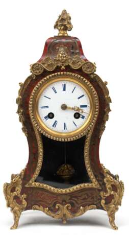Tischuhr, 19. Jh., Gehäuse in geschweifter Barockform mit Marketerie in Messing und Schildpatt-Optik mit Fehlstellen, sowie reichen Bronze-Applikationen, emailliertes Zifferblatt mit Haarrissen und beschäd., 1/2-Stundens… - Foto 1