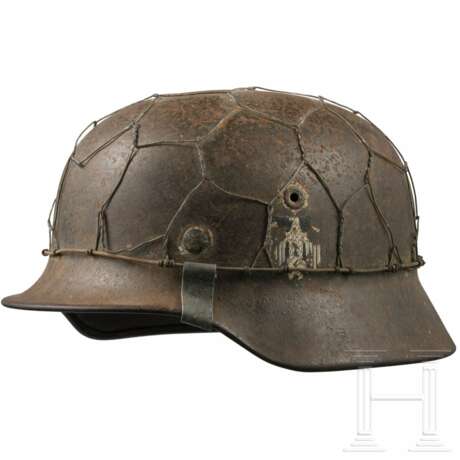 Stahlhelm M 35 des Heeres mit einem Abzeichen und Drahtnetz - Foto 1