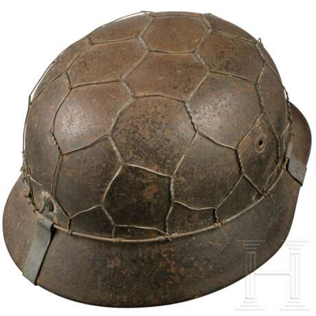 Stahlhelm M 35 des Heeres mit einem Abzeichen und Drahtnetz - Foto 4