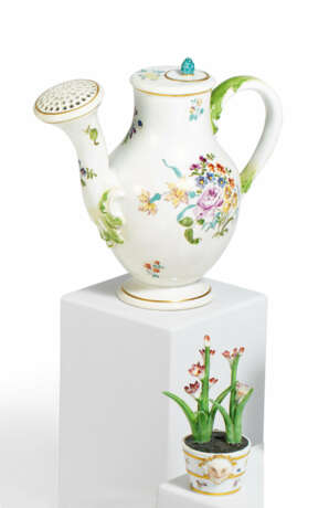 Kleine Gießkanne und Miniatur Blumentopf mit blühender Pflanze - Foto 1