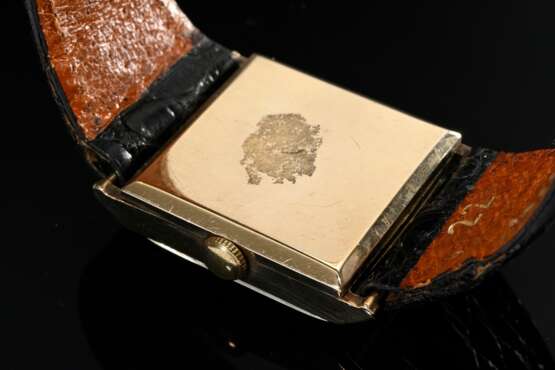 J.W. Benson Gelbgold 375 Armbanduhr, Handaufzug, quadratisches Gehäuse mit arabischen Zahlen und Minutenindizes, kleine Sekunde bei „6“, schwarzes Lederarmband mit vergoldeter Dornschließe, London um 1950, 3,3x2,5cm, gan… - Foto 2