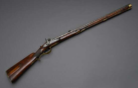 Vorderlader Perkussionsgewehr (Wallbüchse), beschnitzter Nussbaum-Vollschaft, Messing- und Eisenmontierungen, gezogener Achtkantlauf, Kaliber 16mm, L. 110cm, Ladestock (fest), 18./19.Jh., div. Defekte - photo 1