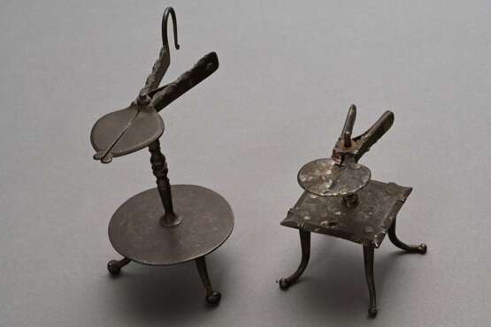 2 Antike Schmiedeeisen Wachstock Halter, Deutsch oder Niederlande 18.Jh.: mit quadratischer Platte auf 4 vernieteten Füßchen (H. 10,3cm) und mit runder Bodenplatte auf 3 Kugelfüßchen (H. 16,5cm), Alters- und Gebrauchsspu… - Foto 1
