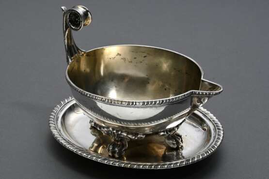 Ovale Sauciere im Empire Stil mit eingerollter Blütenhandhabe und 4 Tatzenfüßen und eingerollter Blütenhandhabe auf festem Unterstand, Gebr. Friedländer, Silber 800, innen vergoldet, 542g, 14,2x14x19cm - photo 1