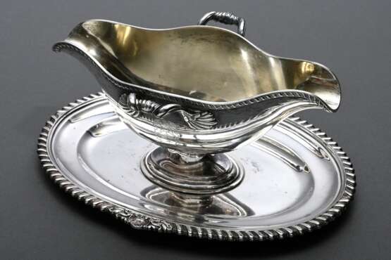 Große Sauciere auf festem Unterstand mit Rillen- und Muschelrelief, Wappengravur, MZ: Gebr. Friedländer, Silber 925, innen vergoldet, 659g, 10,5x24x17cm - photo 1