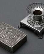 Каталог товаров. 2 Diverse Teile französisches Silber, 19.Jh.: Tabatiere mit klassizistischem Motiv auf dem Deckel (1,5x6,5x4,3cm) und Miniaturleuchter auf Tatzenfüßen (H. 4cm), Punzen verschlagen, Silber innen vergoldet, zus. 107g