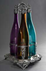 Versilberte Menage mit halbplastischem Weinranken und -trauben Dekor sowie 3 farbigen Weinflaschen in violett, grün und gelb mit versilberten Korken und Hälsen, wohl England 2. Hälfte 19.Jh., H. 41,2cm, durchgeputzt, gel…