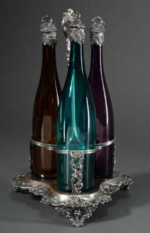 Versilberte Menage mit halbplastischem Weinranken und -trauben Dekor sowie 3 farbigen Weinflaschen in violett, grün und gelb mit versilberten Korken und Hälsen, wohl England 2. Hälfte 19.Jh., H. 41,2cm, durchgeputzt, gel… - photo 2