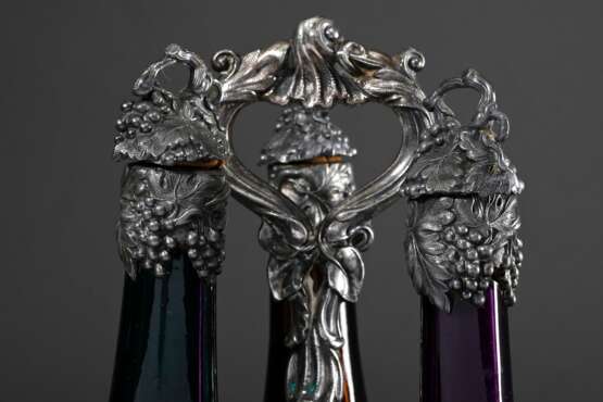 Versilberte Menage mit halbplastischem Weinranken und -trauben Dekor sowie 3 farbigen Weinflaschen in violett, grün und gelb mit versilberten Korken und Hälsen, wohl England 2. Hälfte 19.Jh., H. 41,2cm, durchgeputzt, gel… - photo 3