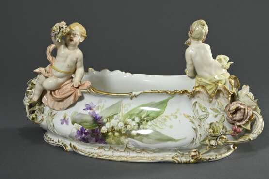 Opulente KPM Jardiniere mit zwei auf dem Rand sitzenden Putti "Mädchen und Junge einen Bouquet haltend", Tuchdraperien nach innen wie außen fallend, große vollplastische Blüten über Volutengriffen, reich relief… - photo 2