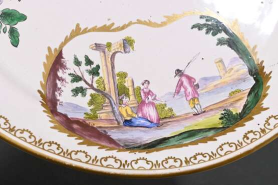 Französische Ecuelle mit zwei Griffen und plastischem Birnenknauf (H. 12cm, Ø 17cm) auf Unterteller (Ø 24,7cm), polychromer floraler Dekor "Insekten" und "Genreszenen" in Goldkartuschen mit umlaufende… - photo 7