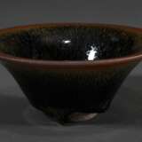 Temmoku Teeschale mit dick auslaufender „Hasenfellglasur“ in ausladender Form, dunkler Steinzeugscherben, H. 5,5cm, Ø 13cm, kleine Goldlackrestauration kintsugi am Rand, Vgl.: Mowry, Hare’s Fur, Tortoiseshell, and Partri… - photo 1
