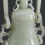 Feine sehr dünnwandige Hotan Jade Deckelvase in Hu-Form mit Flachrelief "Phönixe und Taotie Masken" in archaischem Stil mit beweglichem Bügel und Ringen, in Holzsockel und Präsentoir, dazu Brokat bezogener Kas… - photo 3