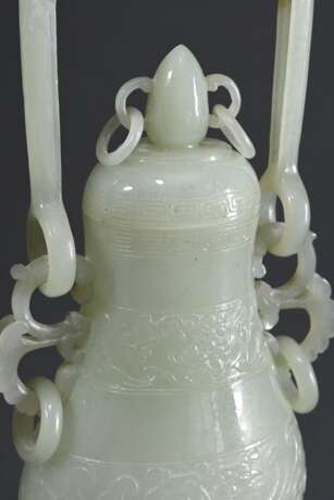 Feine sehr dünnwandige Hotan Jade Deckelvase in Hu-Form mit Flachrelief "Phönixe und Taotie Masken" in archaischem Stil mit beweglichem Bügel und Ringen, in Holzsockel und Präsentoir, dazu Brokat bezogener Kas… - photo 3