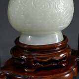 Feine sehr dünnwandige Hotan Jade Deckelvase in Hu-Form mit Flachrelief "Phönixe und Taotie Masken" in archaischem Stil mit beweglichem Bügel und Ringen, in Holzsockel und Präsentoir, dazu Brokat bezogener Kas… - photo 4
