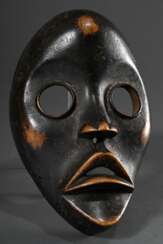 Dan &quot;Zakpäi&quot; Feuerläufer oder -melder Maske mit großen runden Augen, Holz dunkel glänzend gebeizt, schön beriebene Patina, Elfenbeinküste, L. 21,5cm, Ausbrüche am Rand, Provenienz: Sammlung Christian Ries (1899…