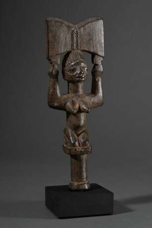 Yoruba-Nago Tanzstab "Ogo-Elegba", Nigeria oder Republik Benin frühes 20.Jh., knieende weibliche Figur auf kurzem Handgriff mit erhobenen Armen, in den Händen das typische Beil des Shango-Donnergottes, braune O… - Foto 1