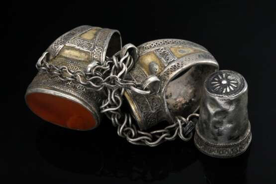 Zwei diverse durch Gliederkette verbundene turkmenische Ringe mit Fingerhut "Kökenli Yüsük", Ringkopf mit großen ovalen Karneole in ornamentaler Fassung auf spitz zulaufender Ringschiene, Silber partiell vergol… - photo 4