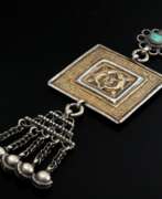 Countries and continents. Indischer Amulettanhänger &quot;Shunga&quot;, rechteckiges Amulett mit Darstellung &quot;Zwei Fische&quot;, Schellenbehang, chinesischen Schriftzeichen und zentralem Türkis, Silber, 34g, L. 13,8cm, Alters- und Gebrauchss…