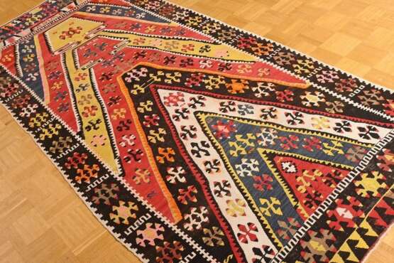 Kelim Teppich mit Zackenmuster in starker Farbigkeit, oben von der Knüpferin sign. "Fadime", partiell offen gearbeitet, Zentralanatolien, Region Kirsehir, um 1950, 290x125cm, Randdefekt, Verfärbungen - фото 1