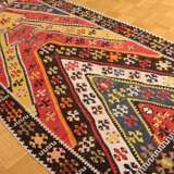 Kelim Teppich mit Zackenmuster in starker Farbigkeit, oben von der Knüpferin sign. "Fadime", partiell offen gearbeitet, Zentralanatolien, Region Kirsehir, um 1950, 290x125cm, Randdefekt, Verfärbungen - фото 1