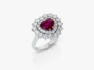 A ring with a heart-shaped ruby and brilliant-cut diamonds.