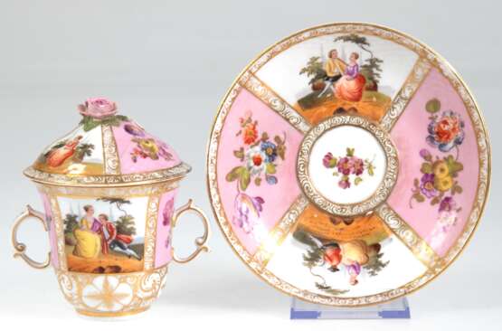Deckeltasse mit UT, Dresden um 1900, August Rex-Marke der Manufaktur Helene Wolfsohn, Glockenbecherform mit 2 Volutenhenkeln, Deckel mit plastischer Blüte als Bekrönung, Ränder mit Korbrelief, Vierfelderdekor, abwechseln… - photo 1