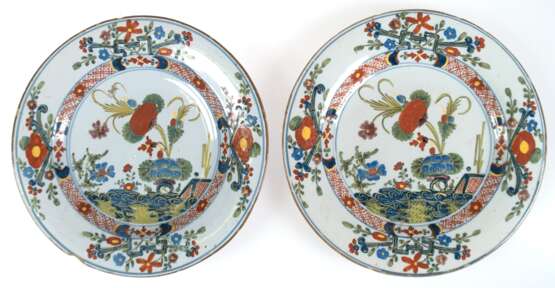 Paar Fayence-Teller, 18. Jh., graublaue Lasur mit floraler Emailmalerei, best. und Riss, Dm. 23,5 cm - photo 1
