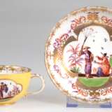 Meissen-Tasse mit UT, Schwertermarke um 1730-35, Obertasse und Unterseite der UT gelb glasiert, Obertasse mit 2 gold umrandeten Reserven mit polychromer Chinoiseriemalerei, UT vollflächig mit Chinoiseriemalerei mit reich… - photo 1