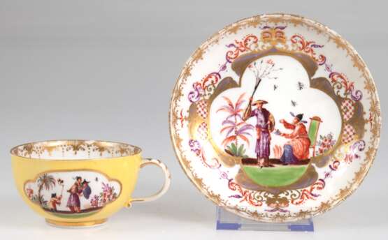 Meissen-Tasse mit UT, Schwertermarke um 1730-35, Obertasse und Unterseite der UT gelb glasiert, Obertasse mit 2 gold umrandeten Reserven mit polychromer Chinoiseriemalerei, UT vollflächig mit Chinoiseriemalerei mit reich… - photo 1