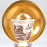 KPM-Tasse mit UT, Anfang 20. Jh., Glockenform mit Campanerhenkel, Schauseite mit Landschaftsdarstellung in Sepiamalerei in goldgerahmter Kartusche, Tasseninneres und Fahne der UT in Gold, Goldränder, blaue Zeptermarke - photo 1