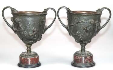 Paar Bronze-Aufsatzschalen, Italien 19. Jh., mit figürlichem Relief und 2 seitl. Henkeln, mit Bronze-Einsätzen, auf Marmorfuß und schwarzem Steinstand, Rand best., Gebrauchspuren, H. 18 cm